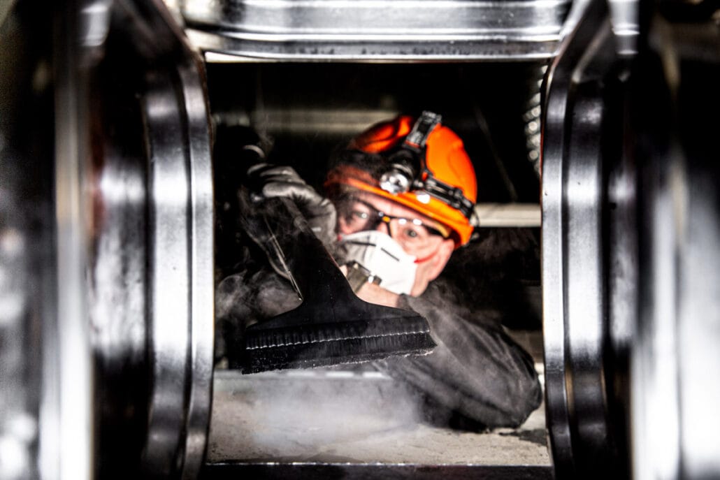 Commercial Photographer Manchester photo of worker cleaning a duct